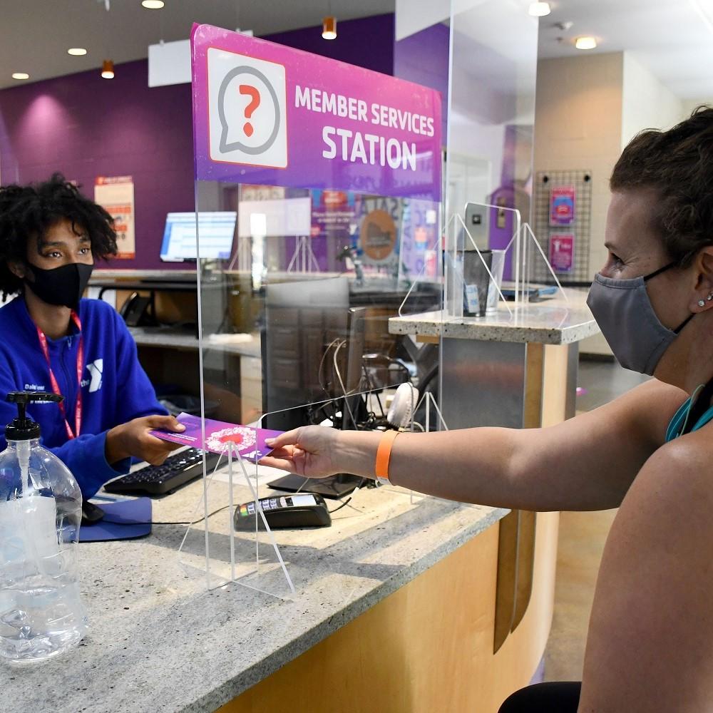2 ladies at a member service desk with masks on